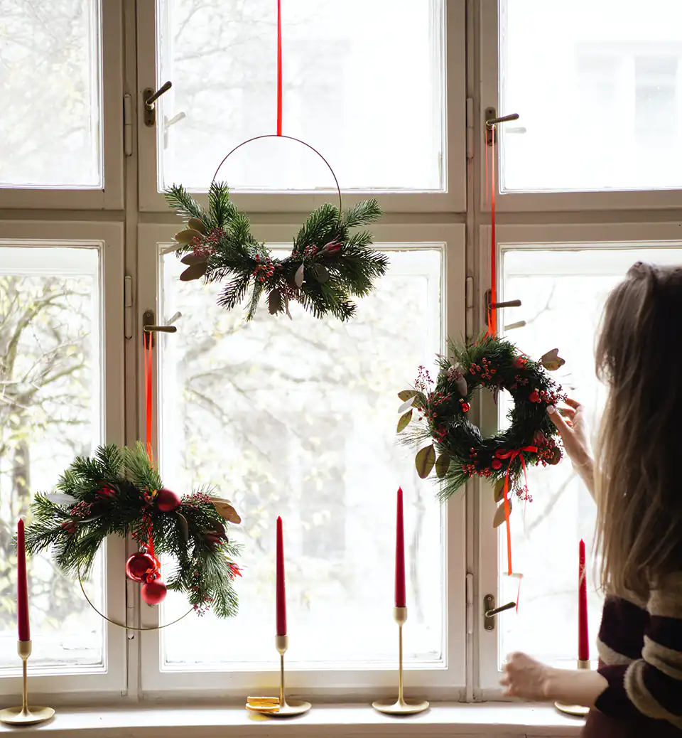 Des couronnes de Noël accrochées à la fenêtre.