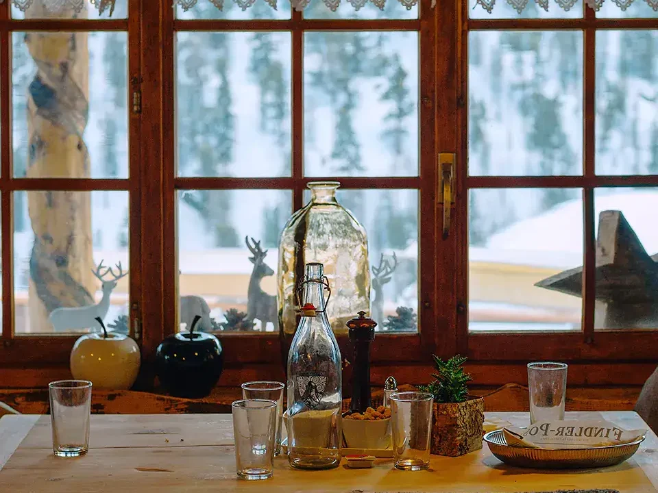 Une maison de campagne de style cottagecore avec vue sur une clairière hivernale.